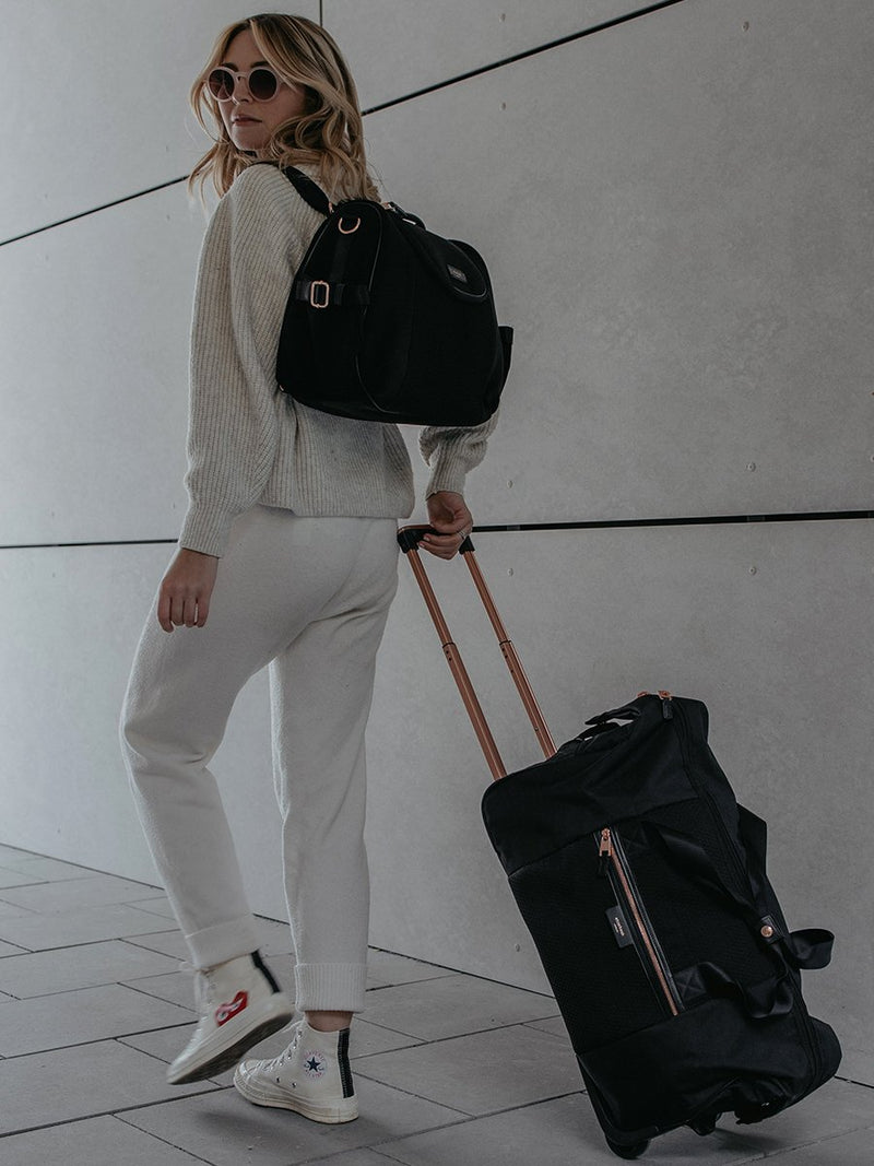 storksak poppy luxe scuba black, convertible changing bag, mum wearing as backpack and carrying matching hospital bag